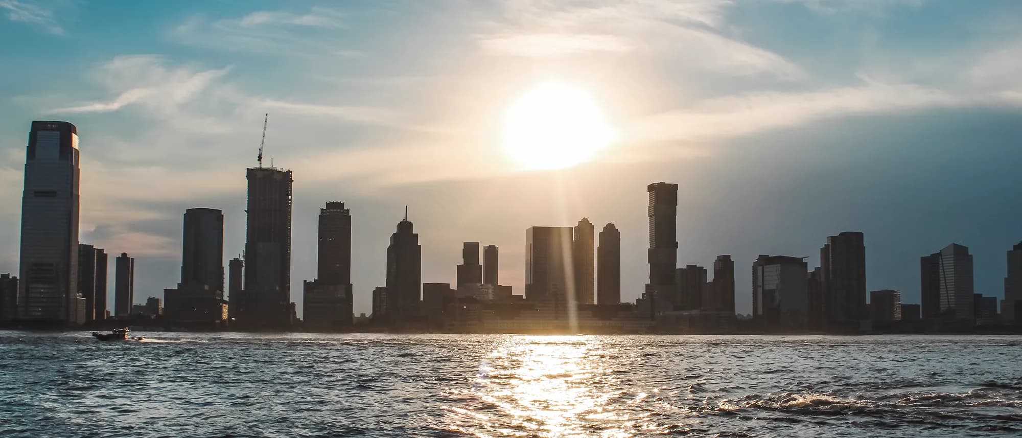 City skyline at sunset across the water, representing the international markets NeoFin Advisors supports