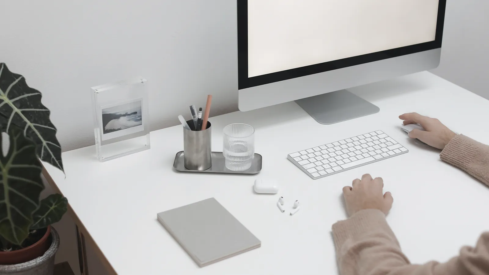 Professional reviewing a financial model on a large monitor at a clean, bright desk