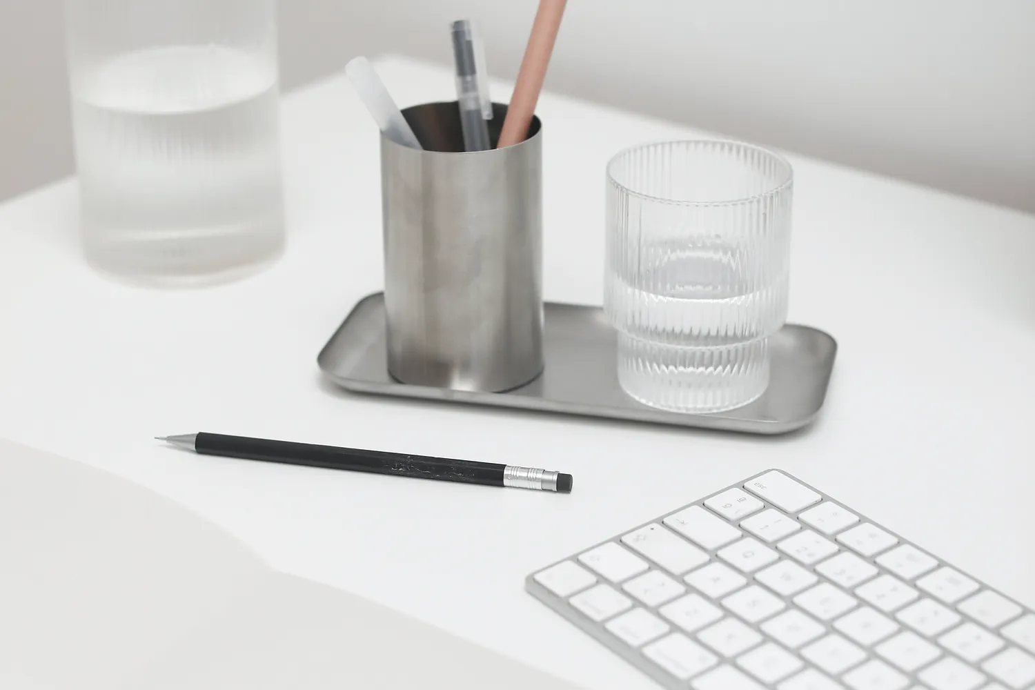 Tidy desk with a keyboard, pen holder and notebook, set up for day-to-day bookkeeping work