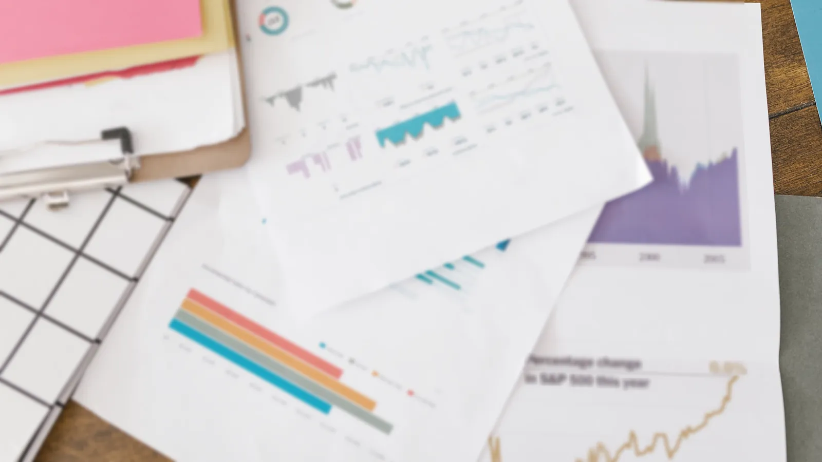 Printed charts and financial reports spread across a desk, ready for a monthly MIS review
